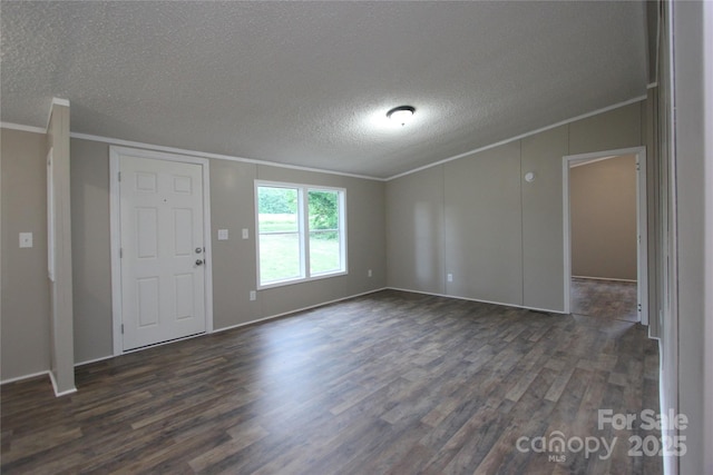 spare room with ornamental molding, dark wood-type flooring, a textured ceiling, and lofted ceiling