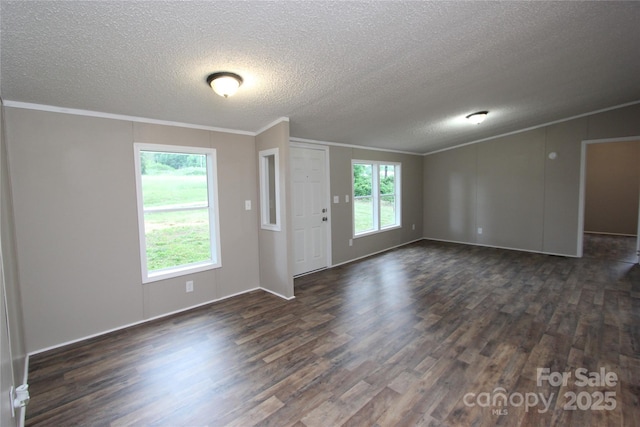 unfurnished living room featuring dark wood finished floors, ornamental molding, a textured ceiling, and baseboards