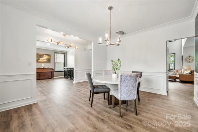 862 Kathy Dianne Dr, Fort Mill, SC 29707 - dining area with a chandelier, ornamental molding, plenty of natural light, a decorative wall, and light wood-style floors