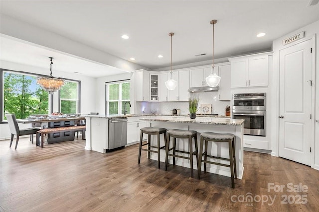 862 Kathy Dianne Dr, Fort Mill, SC 29707 - kitchen featuring appliances with stainless steel finishes, a kitchen breakfast bar, tasteful backsplash, white cabinets, and glass insert cabinets