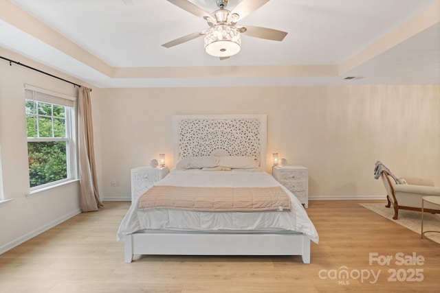 1104 Snowbird Ln, Waxhaw, NC 28173 - bedroom featuring a raised ceiling, light wood-type flooring, and baseboards