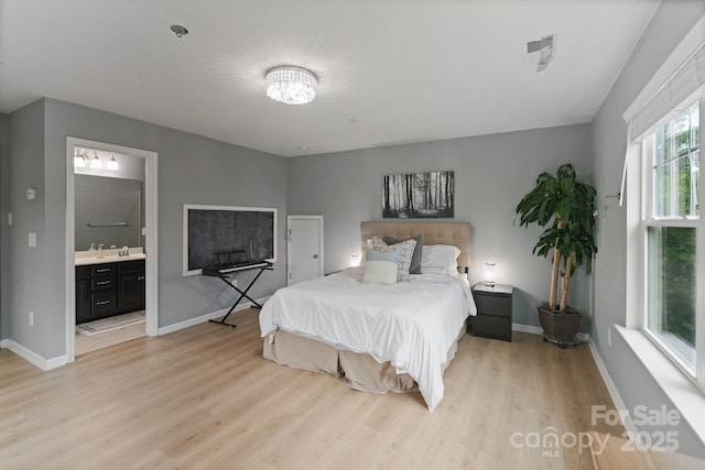 1104 Snowbird Ln, Waxhaw, NC 28173 - bedroom with light wood finished floors, a sink, baseboards, and ensuite bathroom