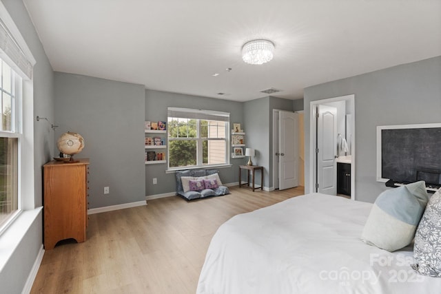 1104 Snowbird Ln, Waxhaw, NC 28173 - bedroom with light wood-style floors, baseboards, a chandelier, and ensuite bath