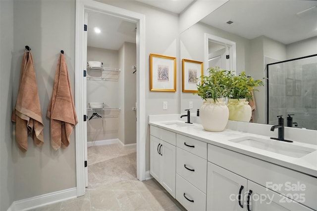 12055 Lavinia Ln, Charlotte, NC 28277 - bathroom featuring double vanity, a spacious closet, a shower stall, and baseboards