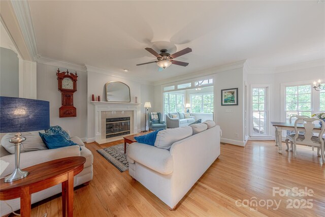 6024 Highview Rd, Weddington, NC 28104 - living room with ornamental molding, light wood-style flooring, a ceiling fan, baseboards, and a high end fireplace