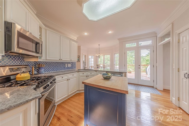 6024 Highview Rd, Weddington, NC 28104 - kitchen featuring stainless steel appliances, butcher block countertops, crown molding, a peninsula, and light wood-type flooring