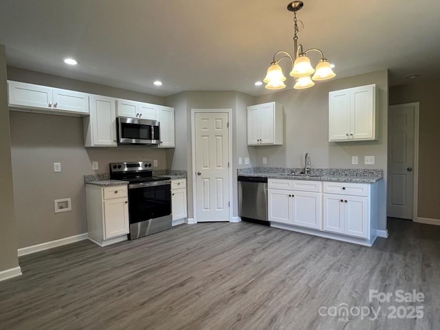 1024 Short St, Salisbury, NC 28144 - kitchen with stainless steel appliances, wood finished floors, white cabinets, recessed lighting, and light stone counters