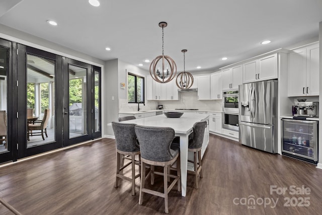 9625 Donna Ve Ln, Charlotte, NC 28277 - kitchen featuring stainless steel appliances, wine cooler, dark wood-type flooring, light countertops, and white cabinetry