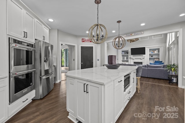 9625 Donna Ve Ln, Charlotte, NC 28277 - kitchen with appliances with stainless steel finishes, a chandelier, a center island, open floor plan, and dark wood-style floors