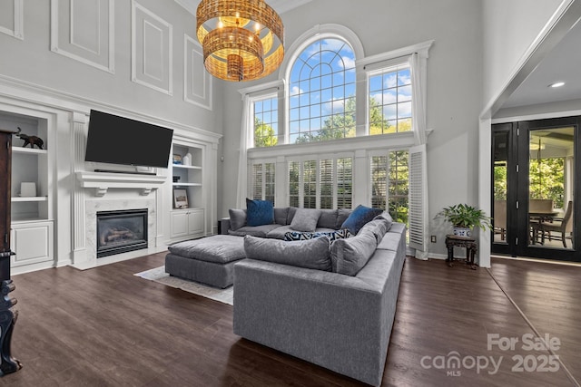 9625 Donna Ve Ln, Charlotte, NC 28277 - living area featuring a high ceiling, a premium fireplace, wood finished floors, built in shelves, and baseboards