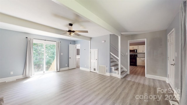8905 Vagabond Rd, Mint Hill, NC 28227 - unfurnished living room with light wood-style flooring, stairs, a ceiling fan, and baseboards