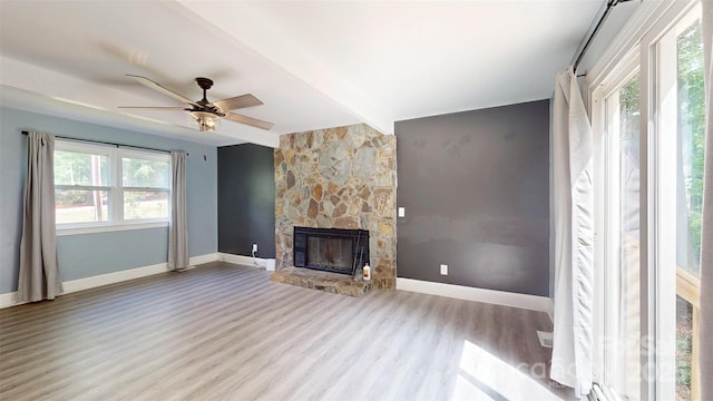 8905 Vagabond Rd, Mint Hill, NC 28227 - unfurnished living room featuring wood finished floors, a stone fireplace, ceiling fan, and baseboards