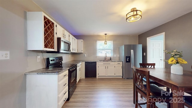 8905 Vagabond Rd, Mint Hill, NC 28227 - kitchen featuring black appliances, white cabinetry, light wood finished floors, decorative light fixtures, and stone countertops