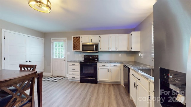 8905 Vagabond Rd, Mint Hill, NC 28227 - kitchen with black appliances, light wood-type flooring, white cabinetry, light stone counters, and baseboards