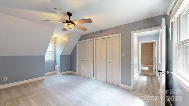 8905 Vagabond Rd, Mint Hill, NC 28227 - unfurnished bedroom with multiple closets, light carpet, baseboards, lofted ceiling, and ceiling fan
