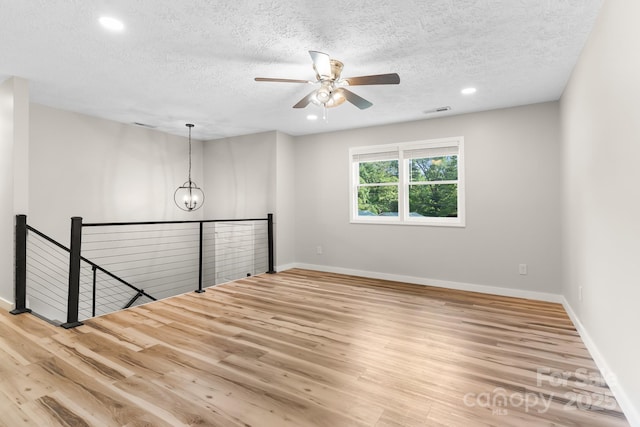 unfurnished room with wood finished floors, a textured ceiling, ceiling fan, baseboards, and recessed lighting