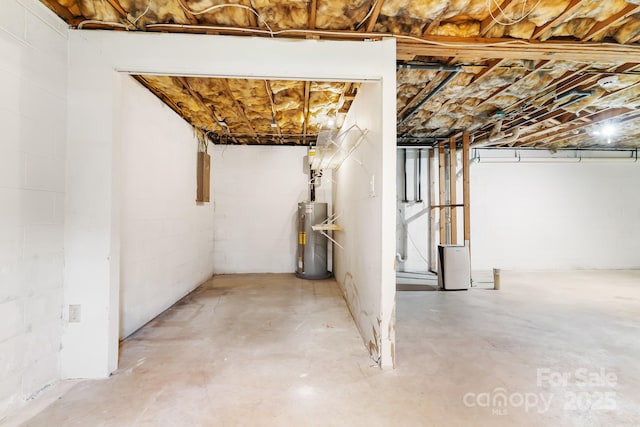 unfinished basement with water heater, concrete block wall, and electric panel