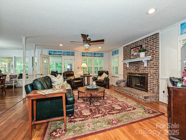 4951 Dayspring Dr, Mint Hill, NC 28227 - living room with ceiling fan, a textured ceiling, wood finished floors, plenty of natural light, and a fireplace