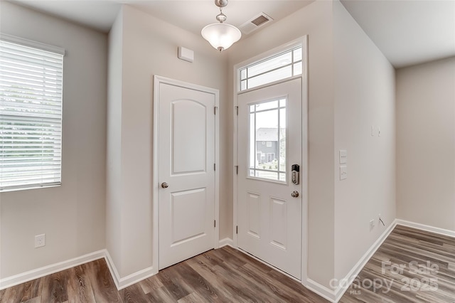 foyer entrance with wood finished floors and baseboards
