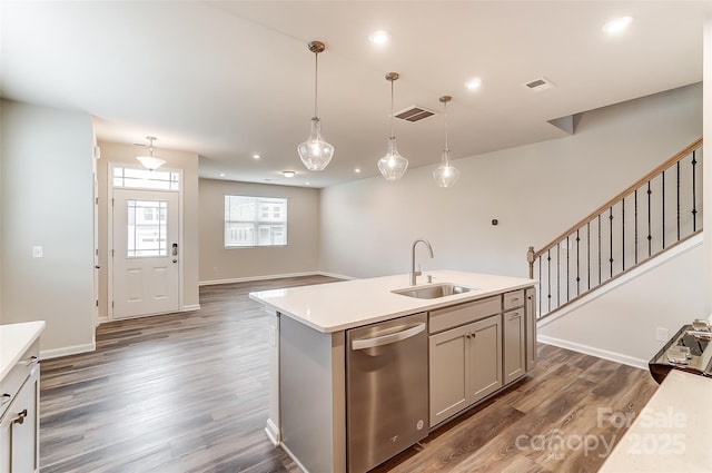 kitchen with stainless steel dishwasher, a sink, light countertops, dark wood finished floors, and recessed lighting