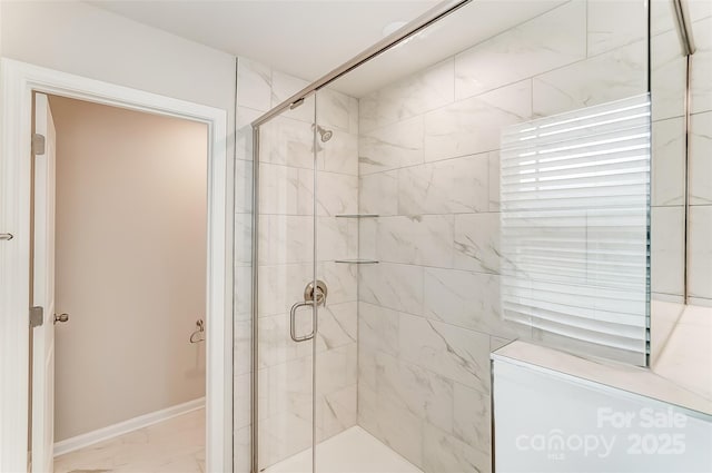 full bathroom featuring a stall shower, baseboards, and marble finish floors