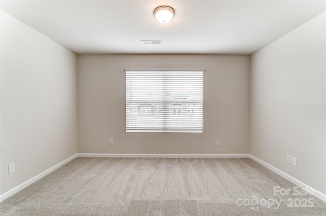 empty room featuring carpet flooring and baseboards