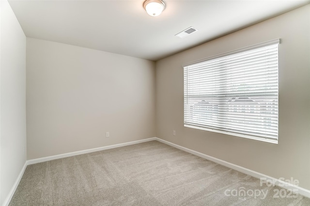unfurnished room featuring light carpet and baseboards