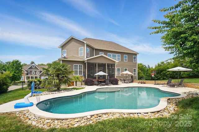 220 Forsythia Ln, Tega Cay, SC 29708 - rear view of house featuring a sunroom, a patio, an outdoor pool, and fence