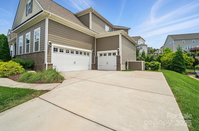 220 Forsythia Ln, Tega Cay, SC 29708 - view of home's exterior featuring brick siding, concrete driveway, a lawn, and a garage