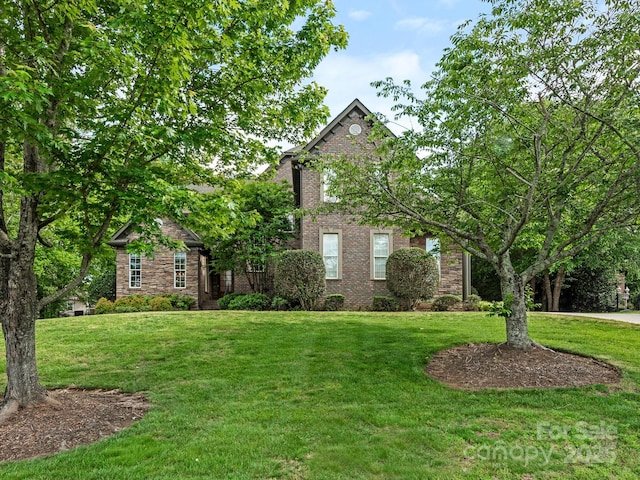 view of front facade with a front lawn and brick siding