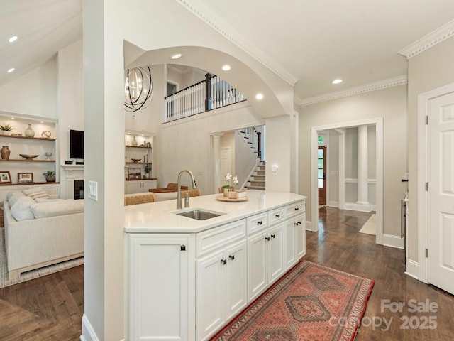 kitchen with a sink, ornamental molding, white cabinetry, recessed lighting, and dark wood-style flooring