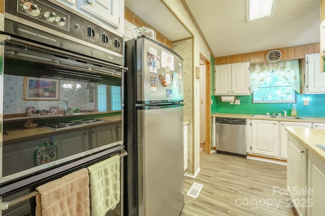 2310 Alexis Lucia Rd, Stanley, NC 28164 - kitchen with appliances with stainless steel finishes, white cabinetry, light wood-style floors, and light countertops