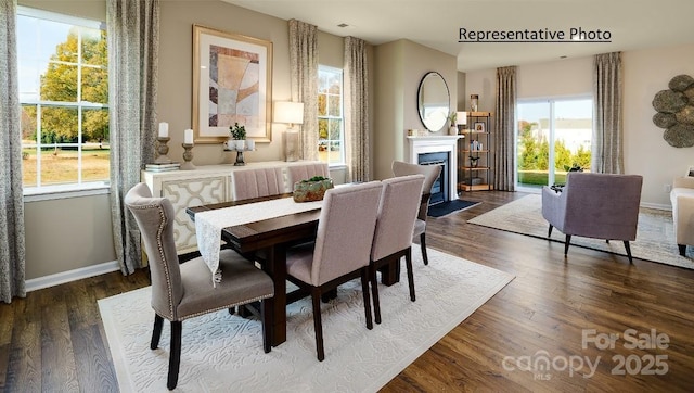 1415 5th Street Dr NE, Hickory, NC 28601 - dining area featuring a fireplace with flush hearth, dark wood-style flooring, and baseboards