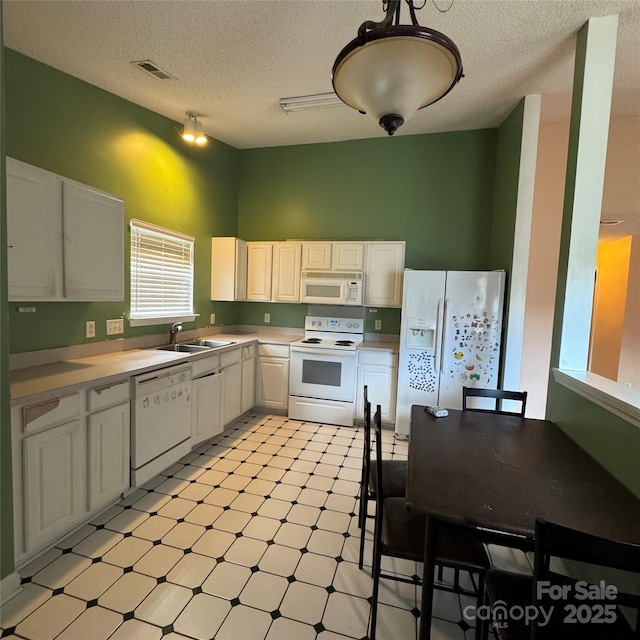 3012 Longspur Dr, Matthews, NC 28105 - kitchen featuring white appliances, light floors, light countertops, a sink, and white cabinetry