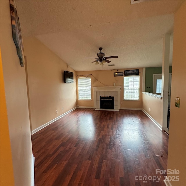 3012 Longspur Dr, Matthews, NC 28105 - unfurnished living room featuring ceiling fan, dark wood-type flooring, healthy amount of natural light, a textured ceiling, and baseboards