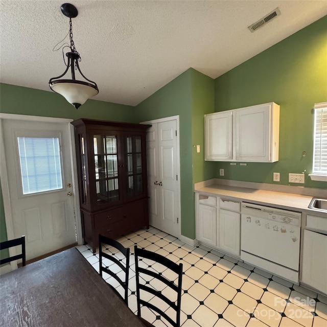 3012 Longspur Dr, Matthews, NC 28105 - kitchen with dishwasher, white cabinetry, light countertops, a textured ceiling, and vaulted ceiling