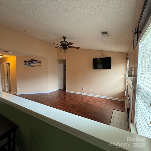 3012 Longspur Dr, Matthews, NC 28105 - unfurnished room with wood finished floors, a textured ceiling, a ceiling fan, baseboards, and lofted ceiling