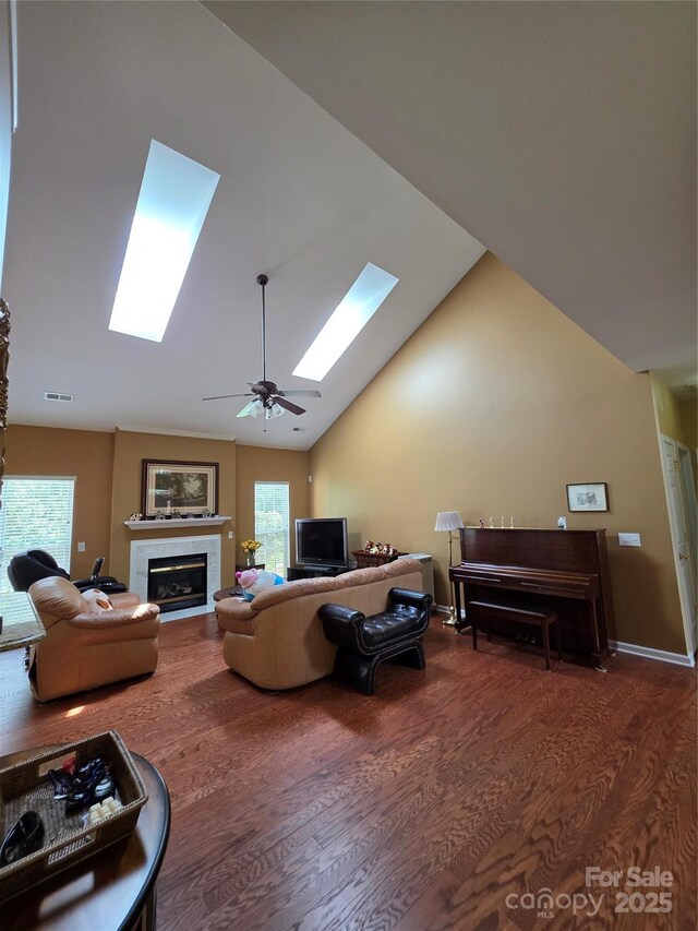 6017 Lowergate Dr, Waxhaw, NC 28173 - living area featuring a skylight, wood finished floors, a glass covered fireplace, a ceiling fan, and high vaulted ceiling