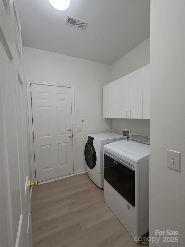 6017 Lowergate Dr, Waxhaw, NC 28173 - clothes washing area featuring washer and dryer, cabinet space, light wood-type flooring, and baseboards