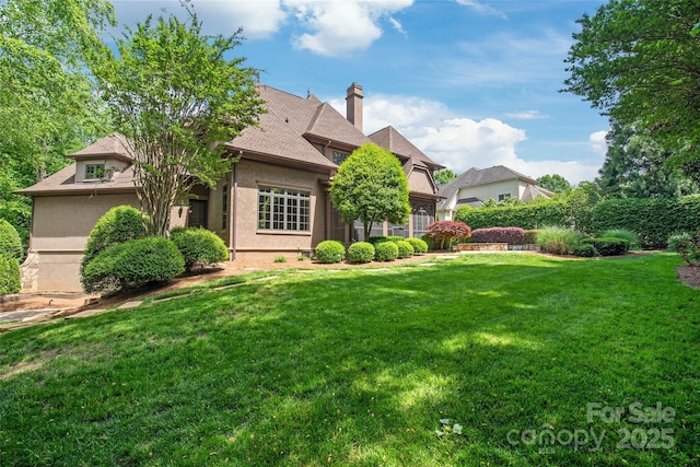 18843 Flat Shoals Dr, Cornelius, NC 28031 - back of property with a lawn, stucco siding, a chimney, and roof with shingles
