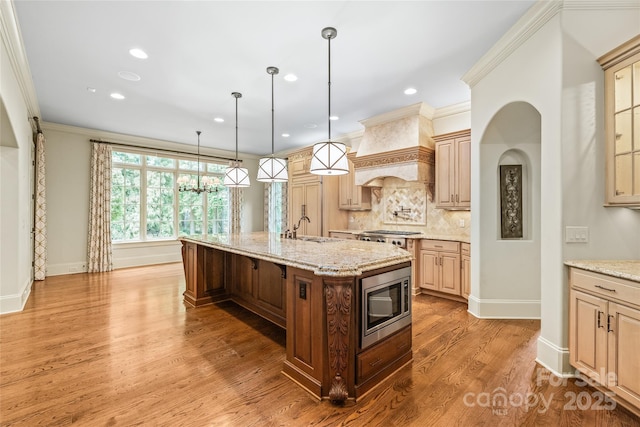 18843 Flat Shoals Dr, Cornelius, NC 28031 - kitchen with stainless steel microwave, a sink, custom exhaust hood, tasteful backsplash, and a center island with sink