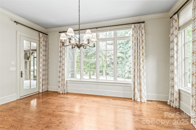 18843 Flat Shoals Dr, Cornelius, NC 28031 - unfurnished dining area with a chandelier, baseboards, wood finished floors, and ornamental molding