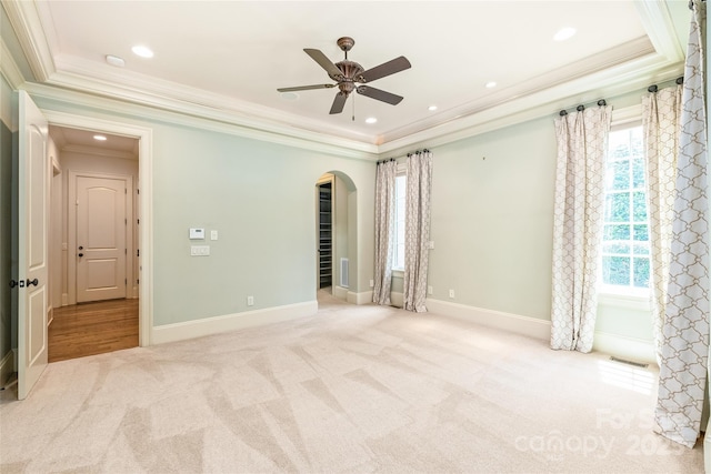 18843 Flat Shoals Dr, Cornelius, NC 28031 - carpeted empty room with crown molding, arched walkways, a raised ceiling, a ceiling fan, and baseboards