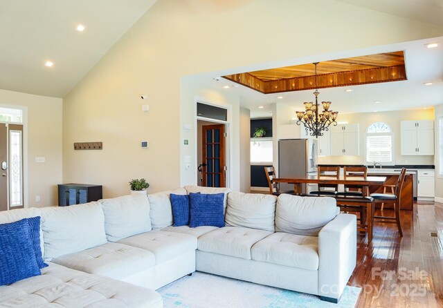 7768 Pinecone Ln, Hickory, NC 28602 - living area with hardwood / wood-style flooring, a chandelier, vaulted ceiling, recessed lighting, and a tray ceiling