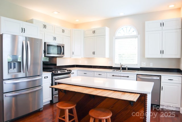 7768 Pinecone Ln, Hickory, NC 28602 - kitchen with appliances with stainless steel finishes, a sink, a kitchen breakfast bar, white cabinets, and light countertops
