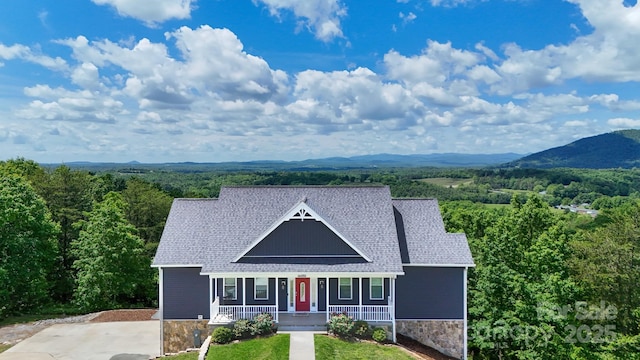 7768 Pinecone Ln, Hickory, NC 28602 - victorian-style house with a porch, a view of trees, a shingled roof, and stone siding