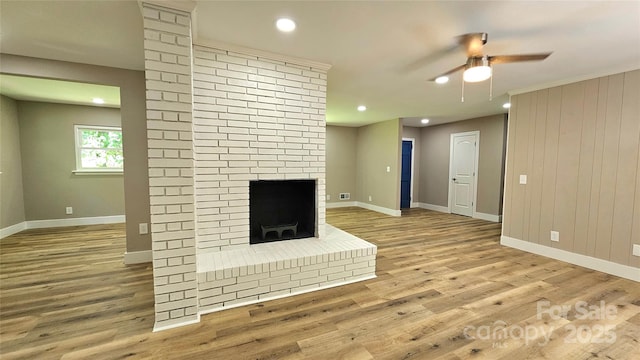 7021 Linda Lake Dr, Charlotte, NC 28215 - unfurnished living room featuring ceiling fan, baseboards, light wood-type flooring, a fireplace, and recessed lighting