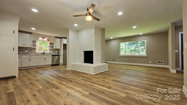 7021 Linda Lake Dr, Charlotte, NC 28215 - unfurnished living room featuring ceiling fan, light wood-type flooring, recessed lighting, a sink, and baseboards