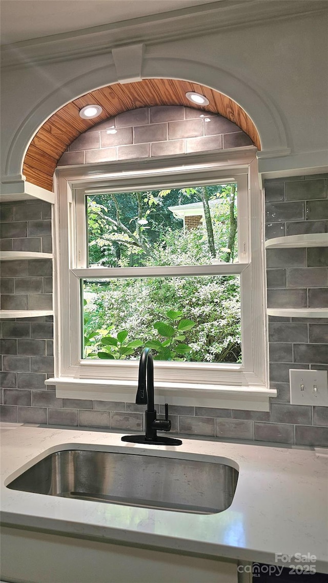 7021 Linda Lake Dr, Charlotte, NC 28215 - kitchen view of a sink, decorative backsplash, and light stone countertops