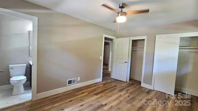 7021 Linda Lake Dr, Charlotte, NC 28215 - unfurnished bedroom with multiple closets, baseboards, and connected bathroom